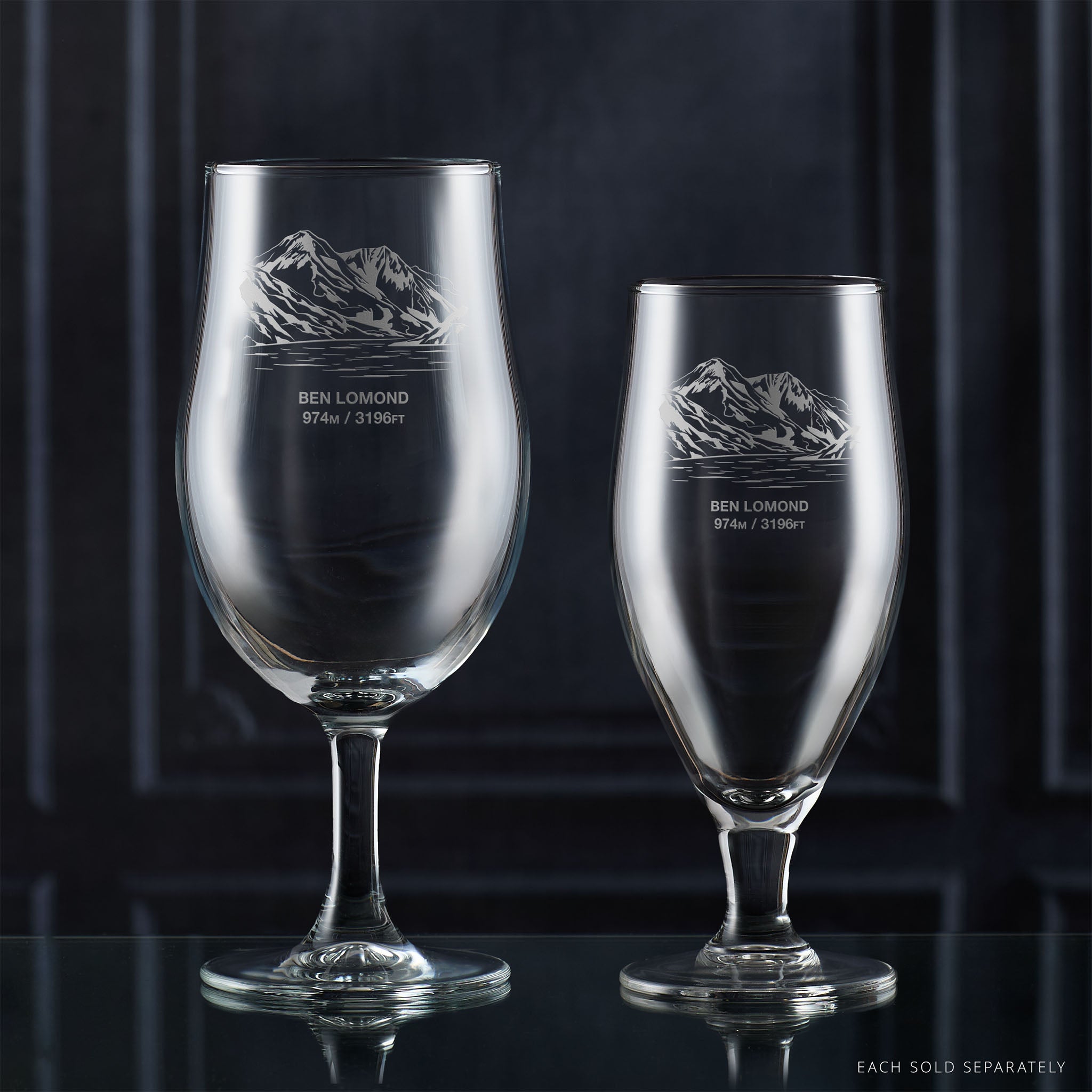 Pair of stemmed beer glasses engraved with Ben Lomond on a reflective surface