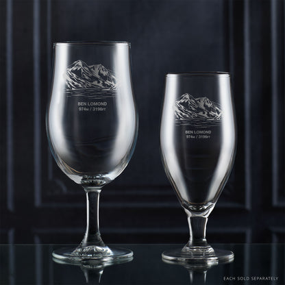 Pair of stemmed beer glasses engraved with Ben Lomond on a reflective surface