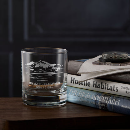 Clear whisky glass engraved with the scottish mountain Ben More placed next to  a stack of books