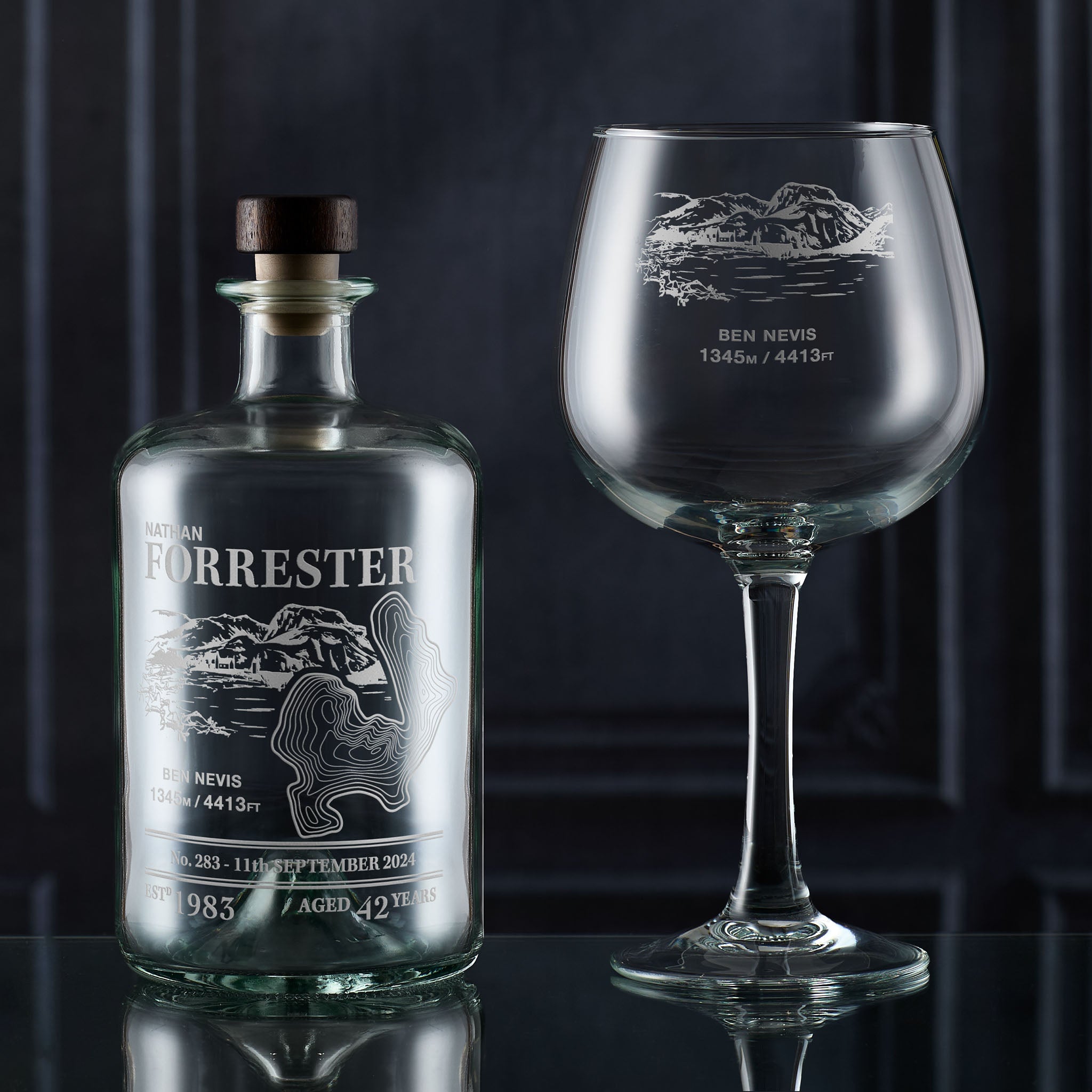 Decanter bottle and personalised gin glass with Ben Nevis mountain engraving on a dark background