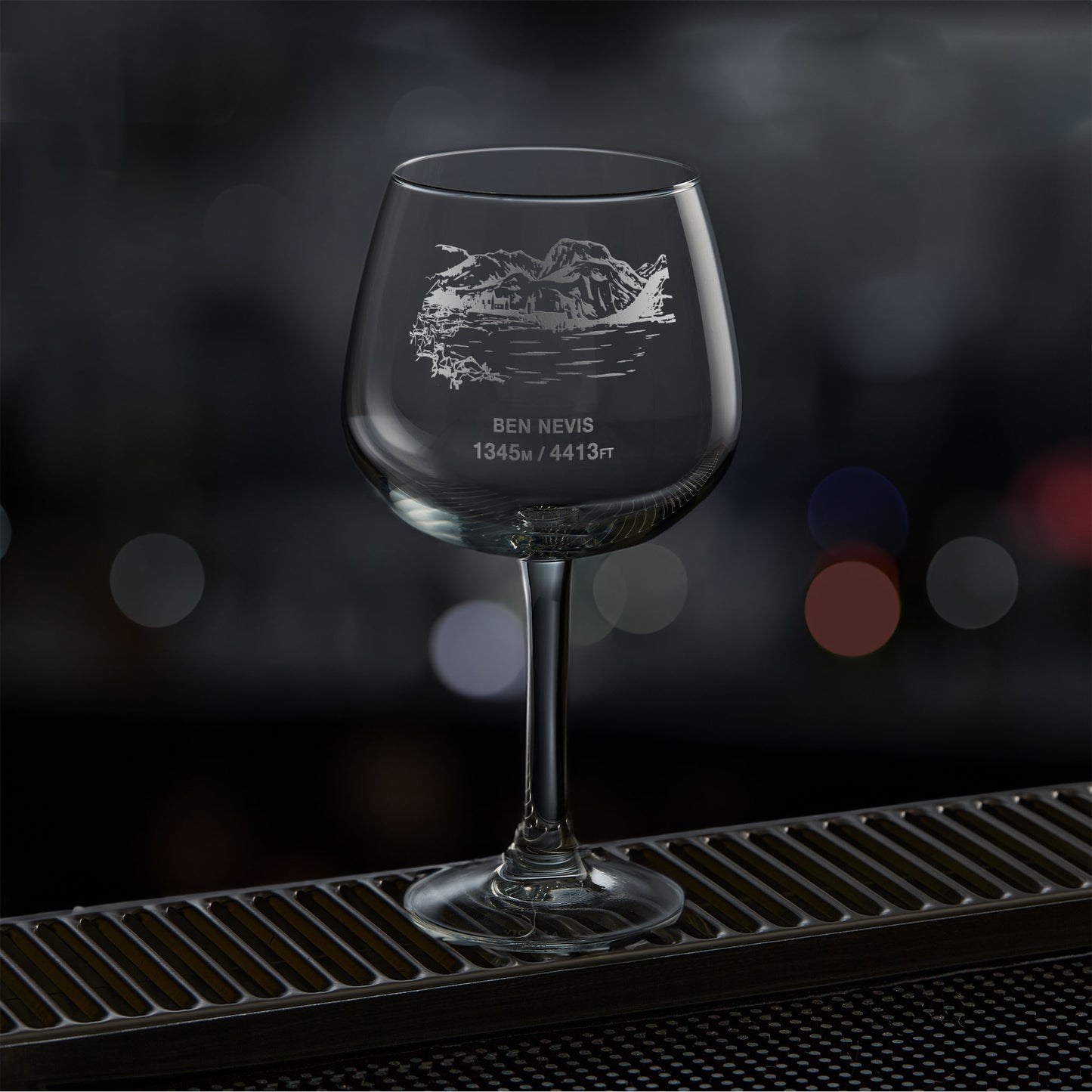 Balloon gin glass engraved with Ben Nevis, photographed on a dark background