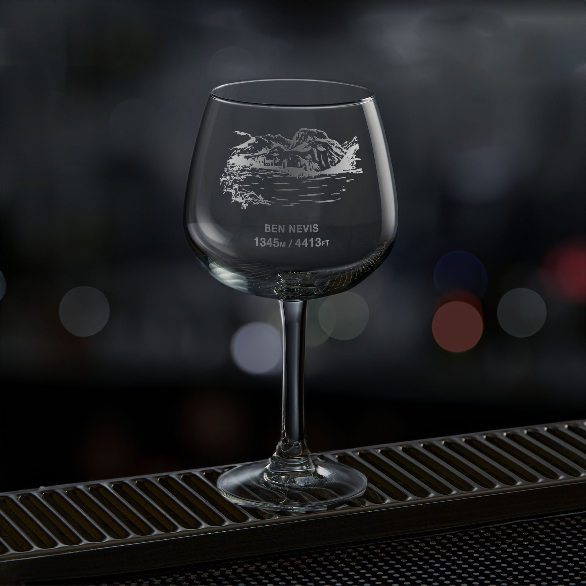 Balloon gin glass engraved with Ben Nevis, photographed on a dark background