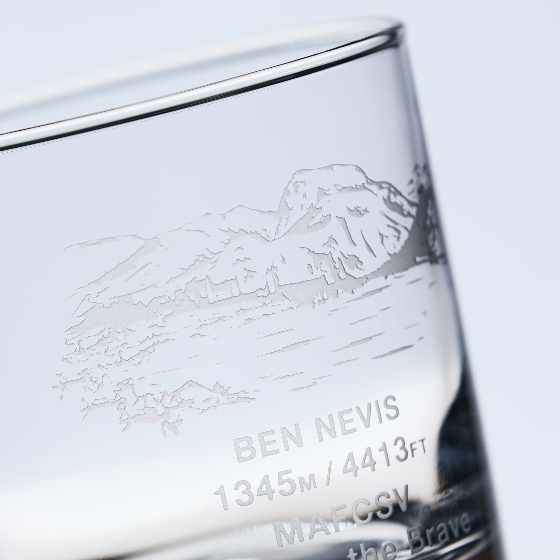 close-up detail of a whisky glass engraved with the Scottish mountain Ben Nevis