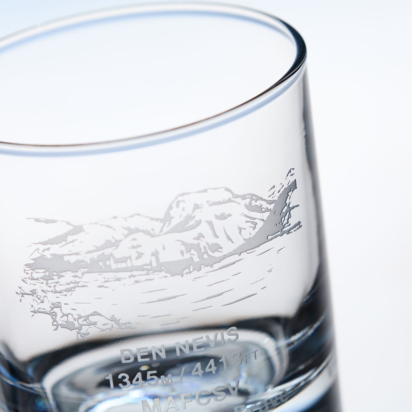 close-up detail of a whisky glass engraved with the Scottish mountain Ben Nevis