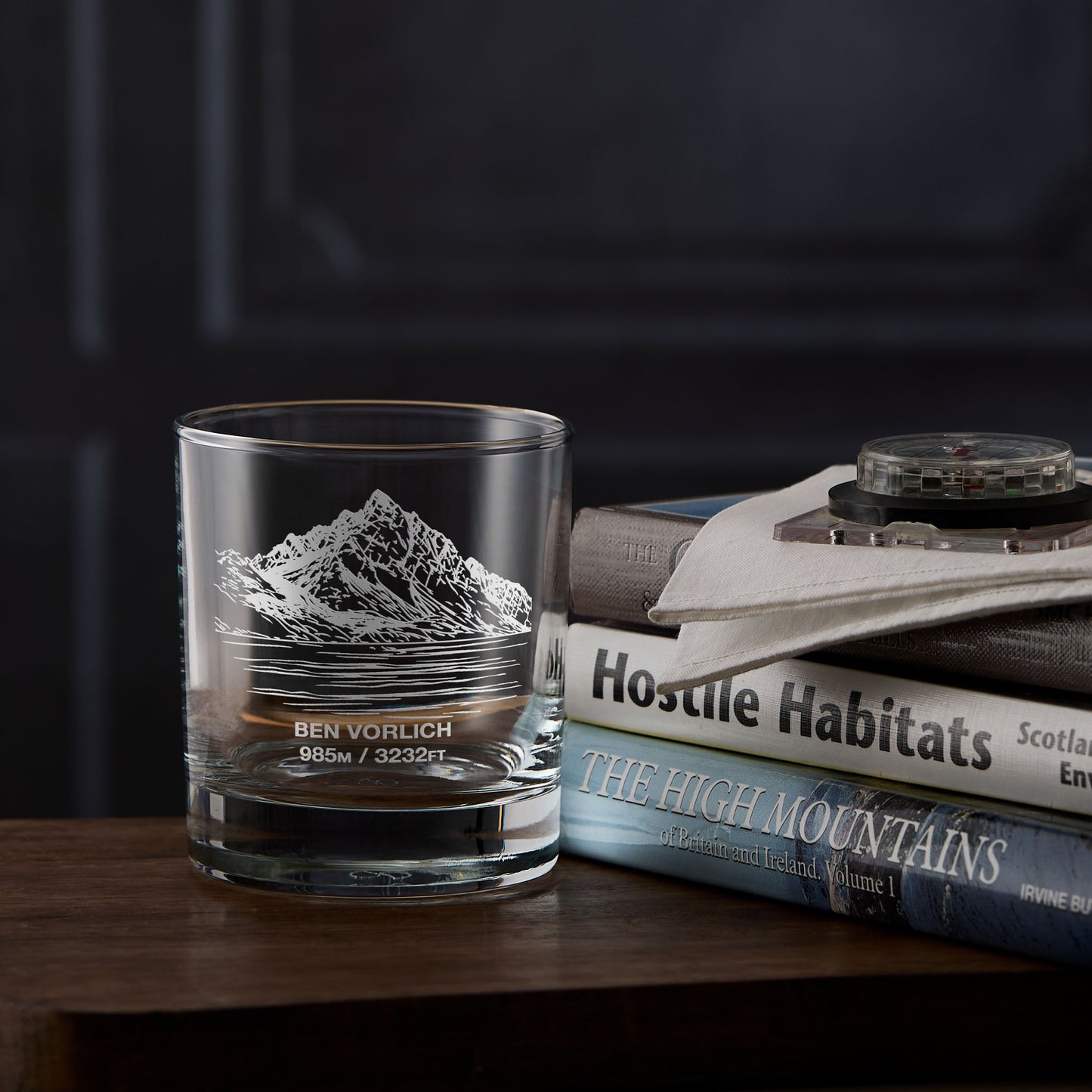 Whisky tumbler with Ben Vorlich mountain engraving on a stack of hillwalking books