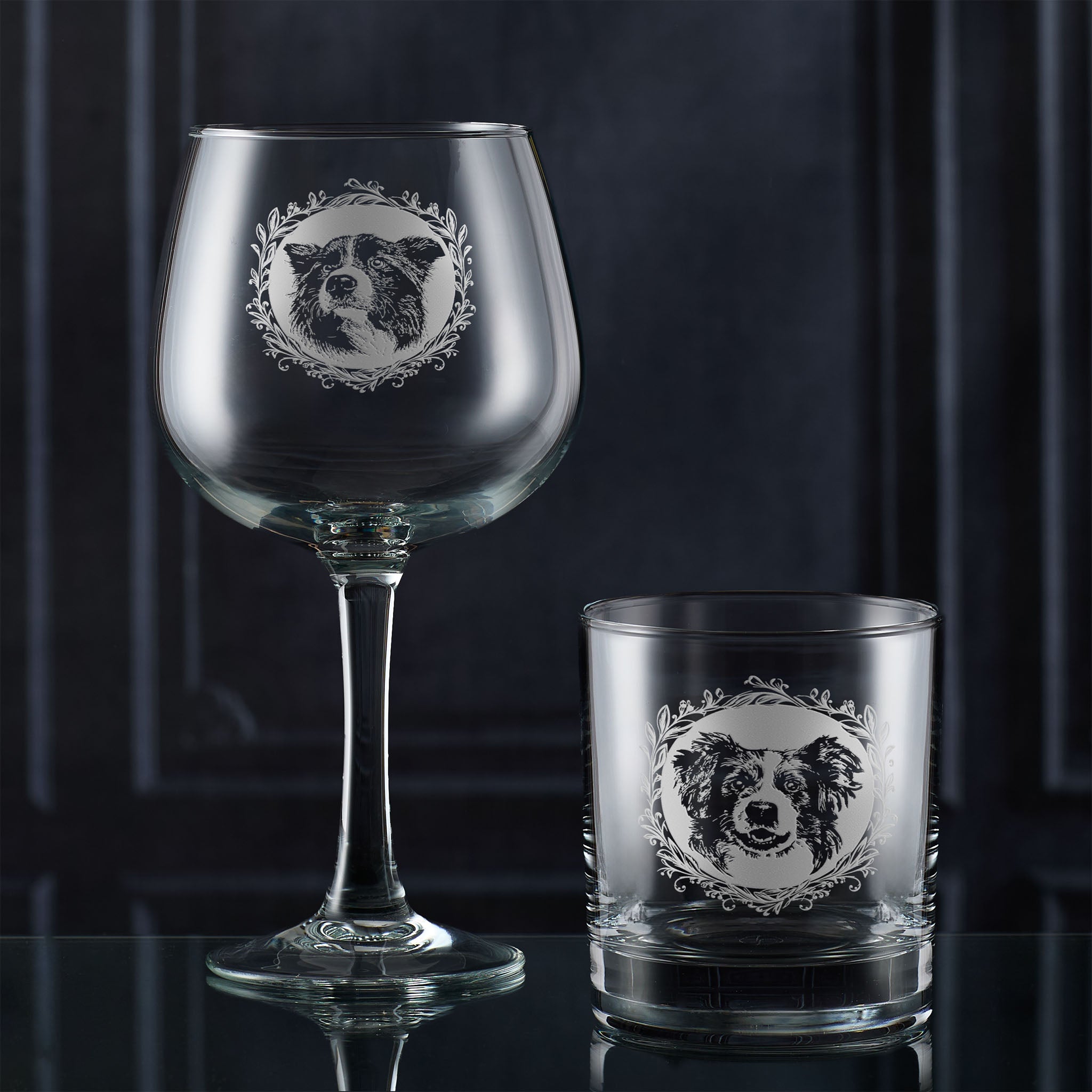 Two glass drinksware items with engraved dog portraits on a dark background