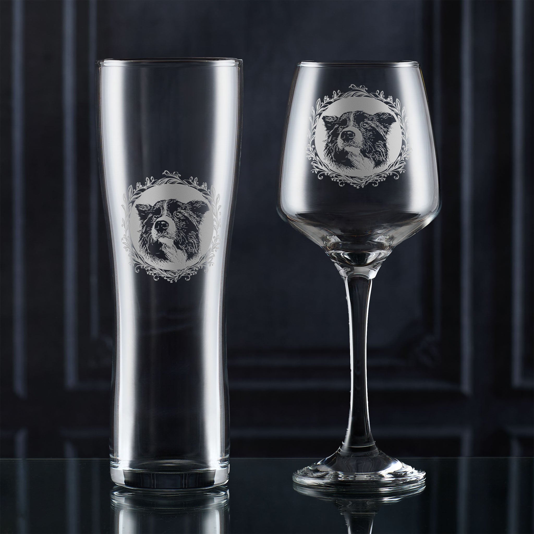 Clear glassware with engraved dogs designs on a dark background