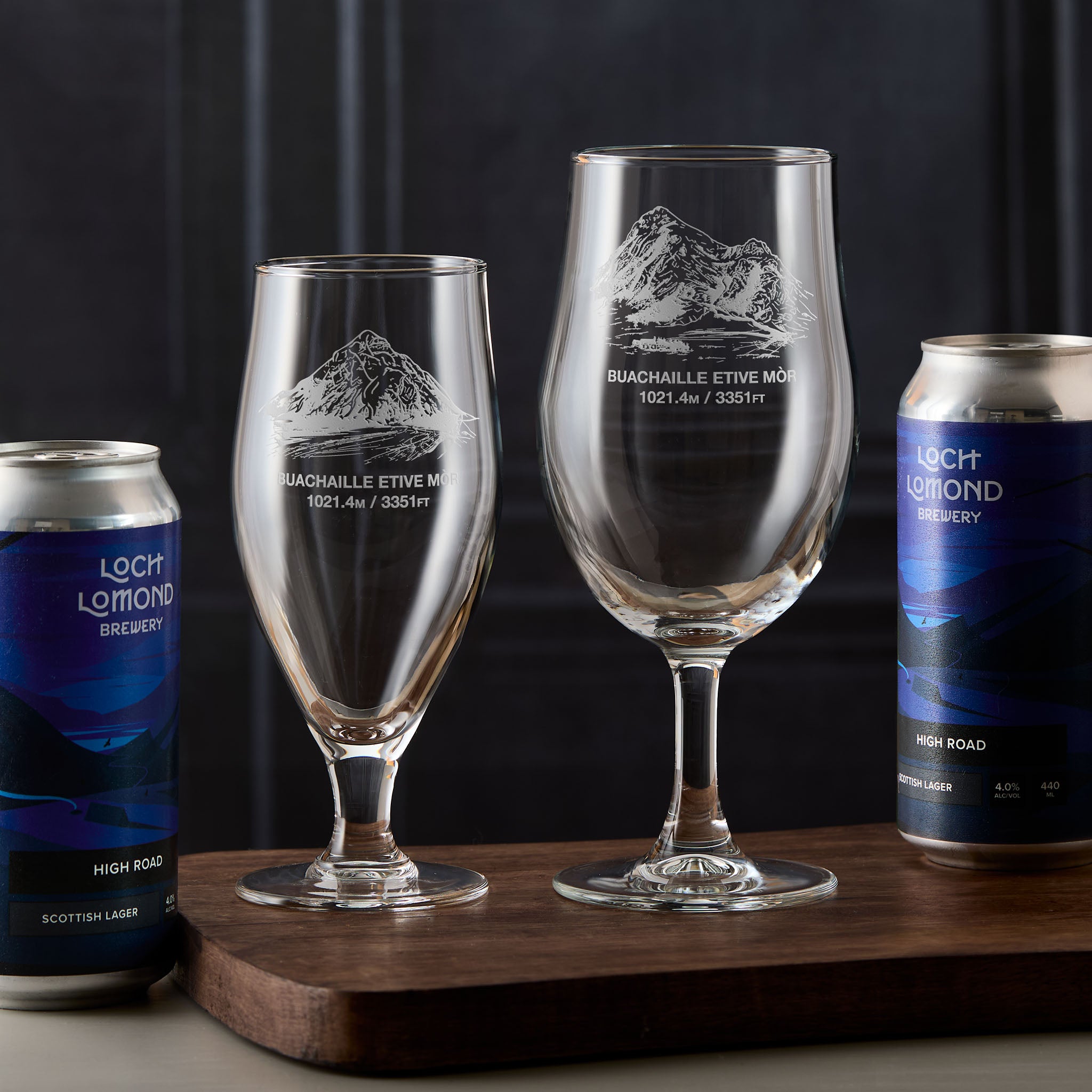 Pair of stemmed beer glasses engraved with Buachaille Etive Mòr, photographed on a wooden board