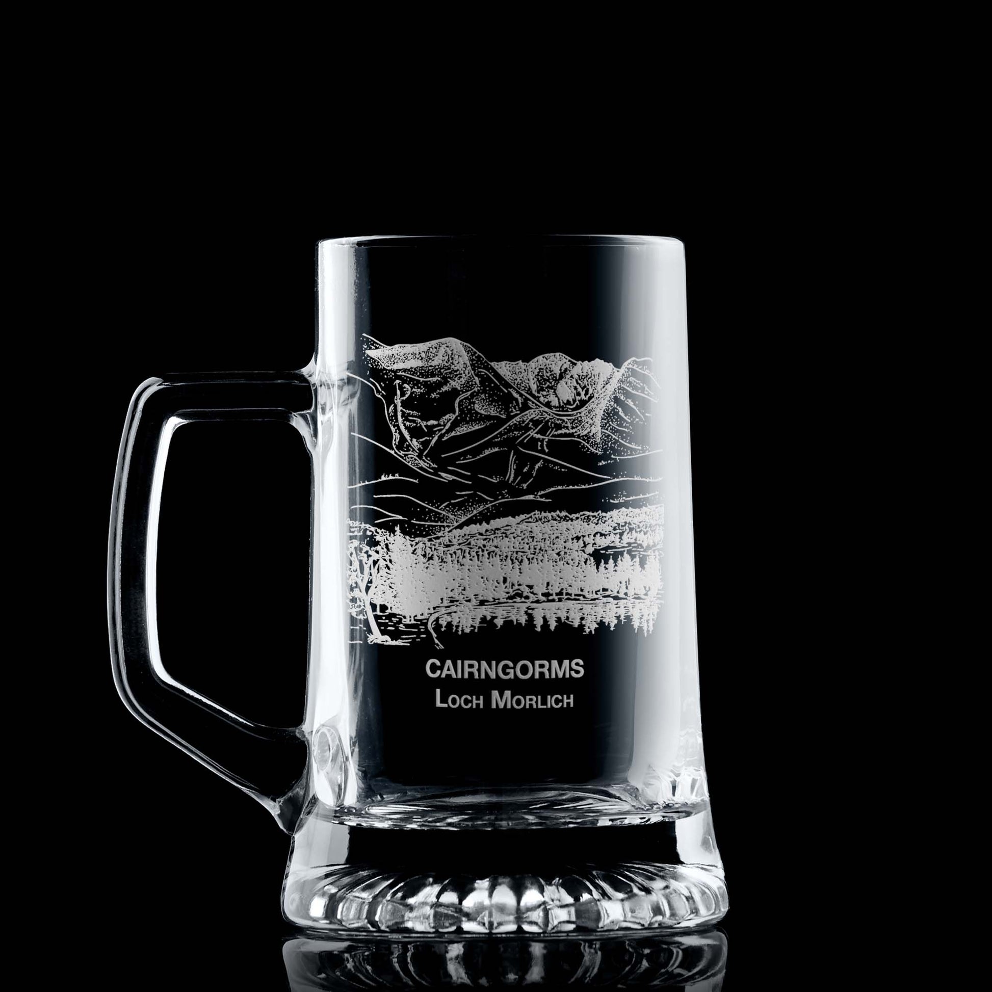 Engraved tankard with Cairngorms and Loch Morlich design shown on black background, handle on left of engraving