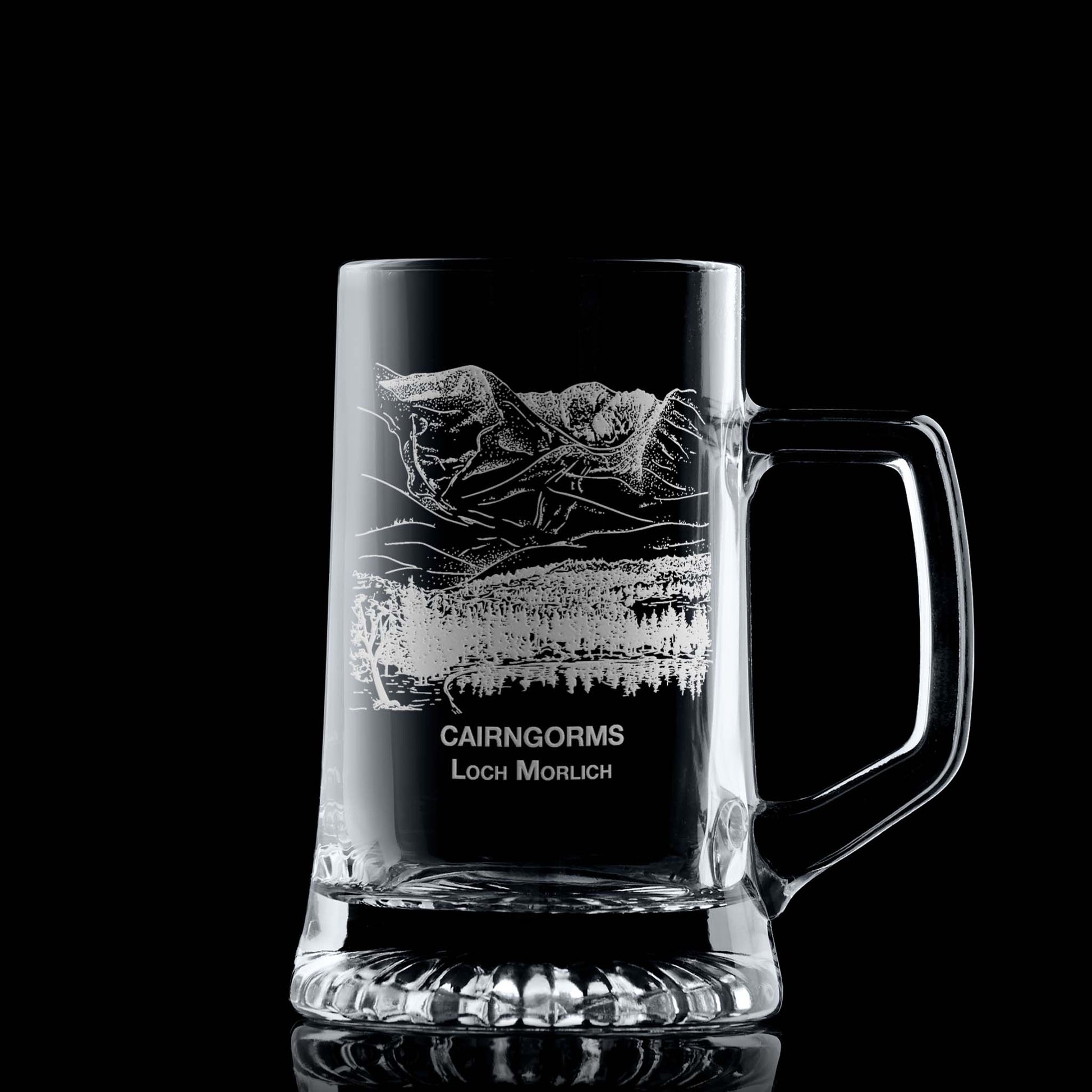 Engraved tankard with Cairngorms and Loch Morlich design shown on black background, handle on right of engraving