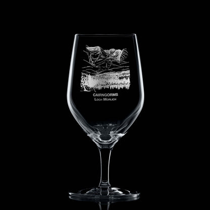 450ml mineral water glass engraved with Cairngorms and Loch Morlich design, shown on black background to highlight engraving