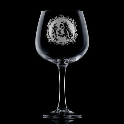 Hand-engraved Cavalier King Charles Spaniel gin glass displayed against dark background featuring a leafy garland dog portrait design by Just The Ticket.