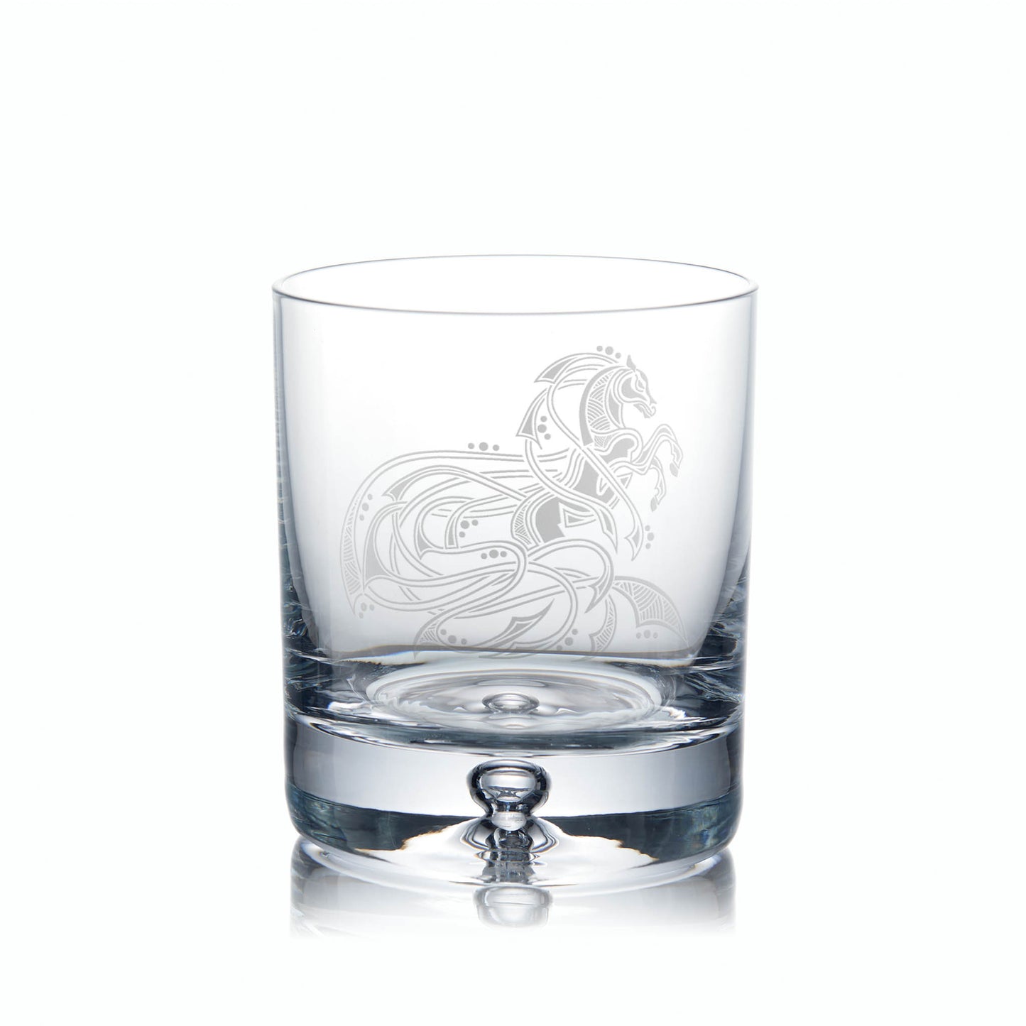 Clear glass tumbler with idelicate horse etching on a white background