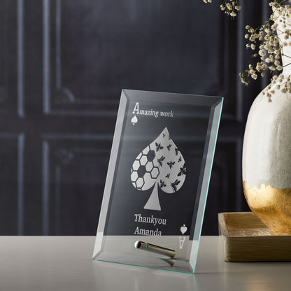Corporate glass award plaque with engraved design and text on a table
