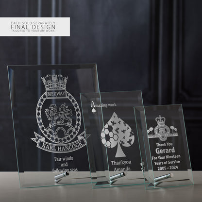 Three engraved glass display plaques with different custom designs on a dark background