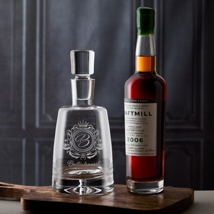 engraved corporate decanter with a bespoke company logo on a wooden surface with a dark textured background