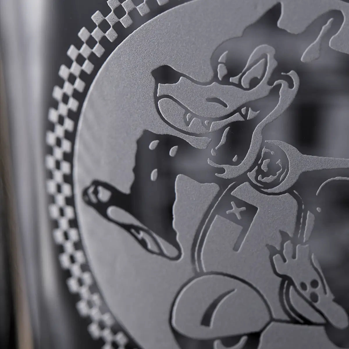 Close-up detail of engraving with a cartoon character design on a glass surface