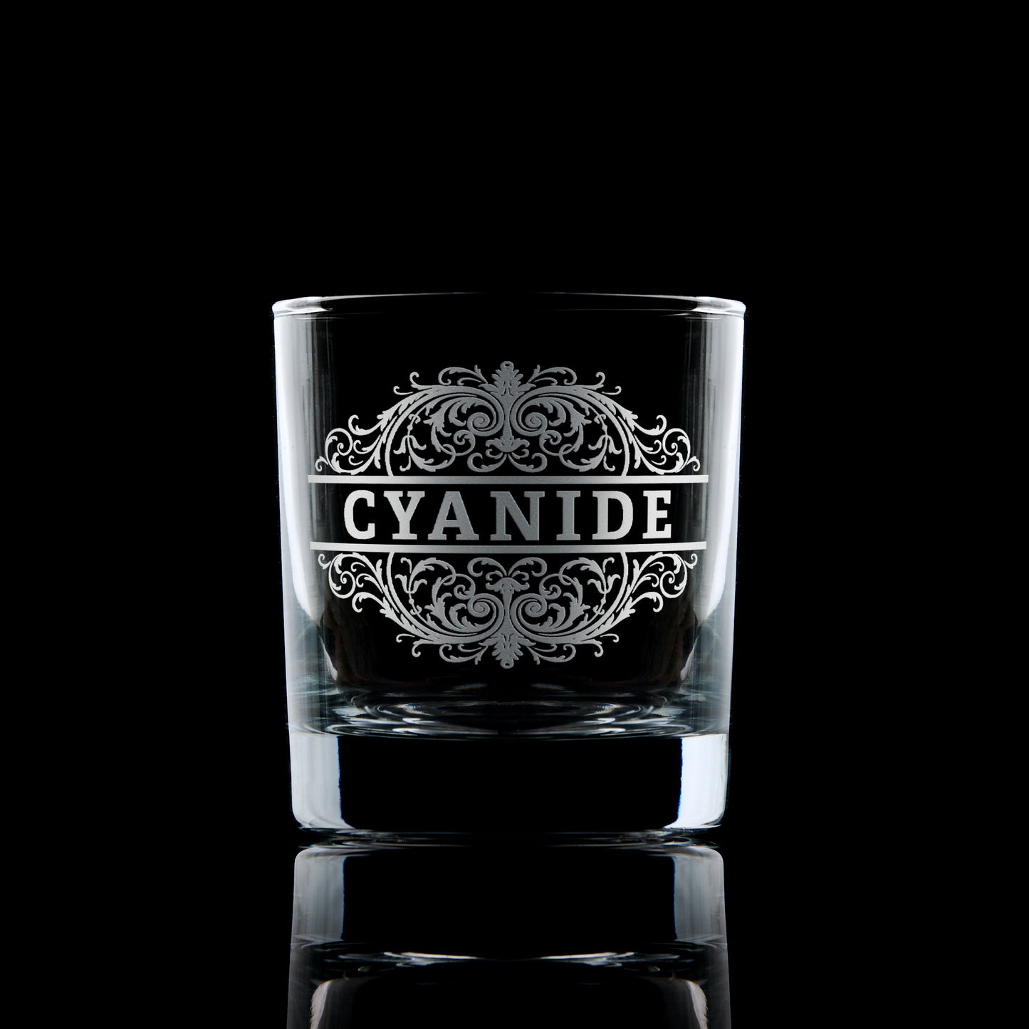 Cyanide engraved whisky tumbler on a dark background.