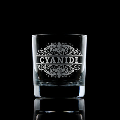 Cyanide engraved whisky tumbler on a dark background.