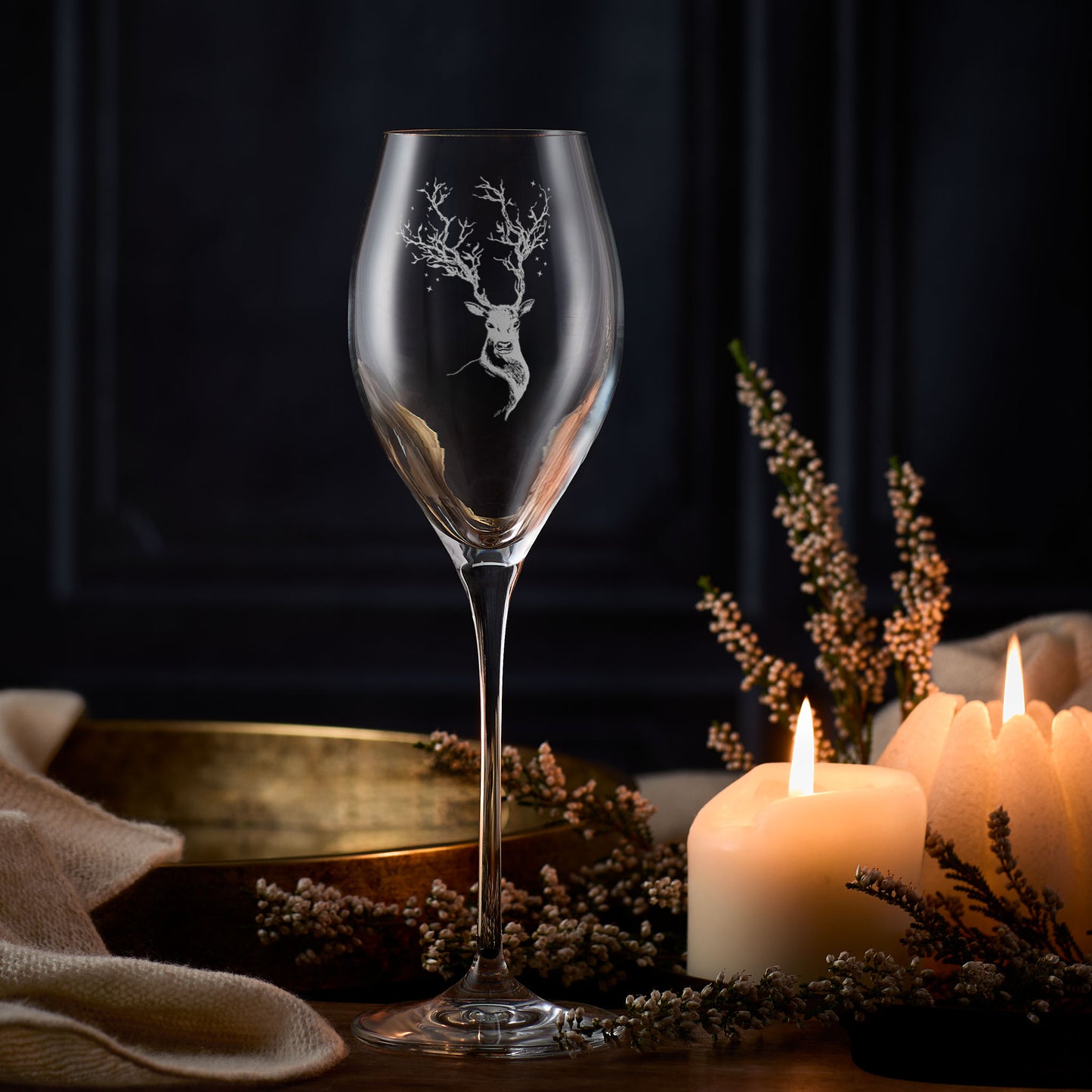 Stag prosecco glass with deer etching on a table with candles and flowers