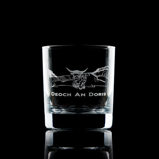 whisky glass engraved with a highland cow in the mountains