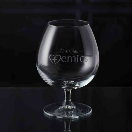 Personalised brandy glass with engraved text on a black background