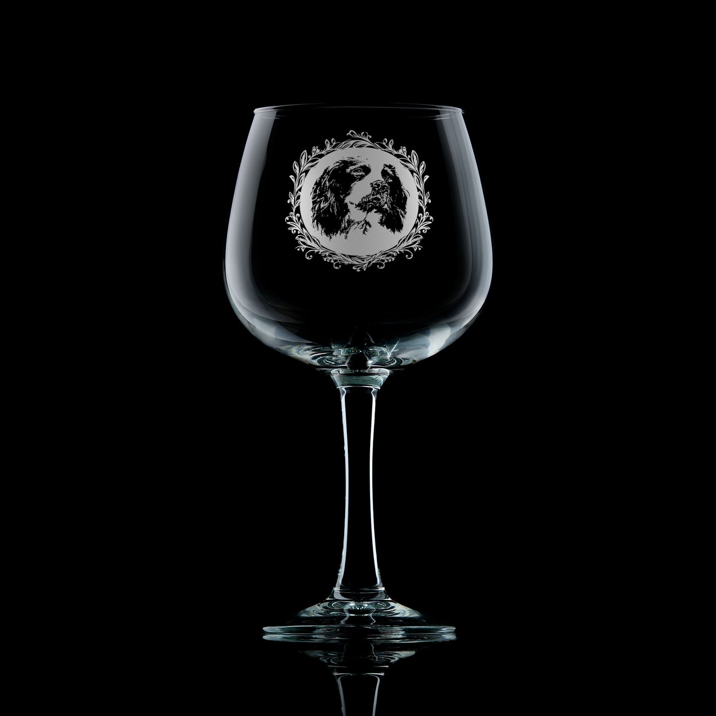 Large gin glass with engraved springer spaniel design on a black background