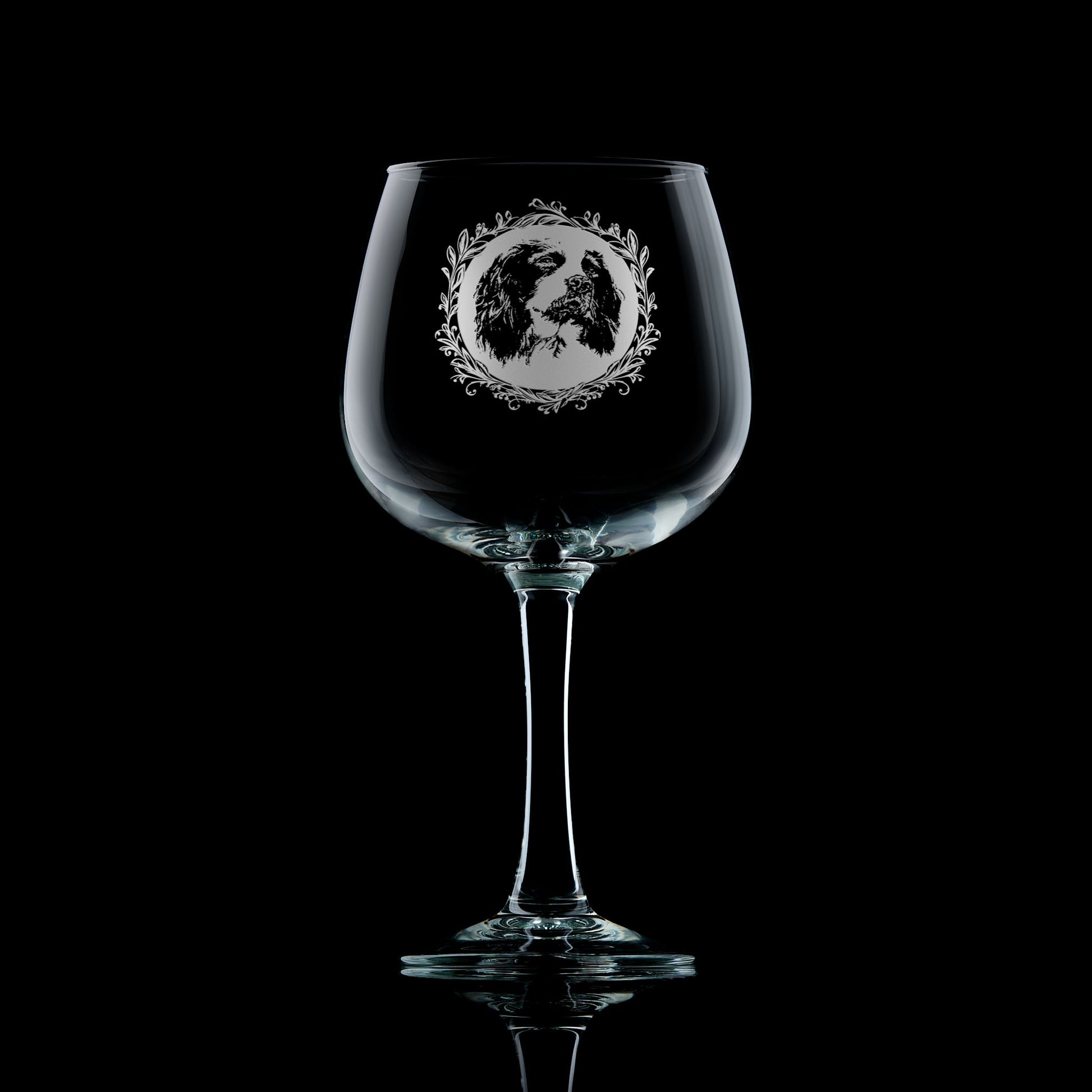 Large gin glass with engraved springer spaniel design on a black background
