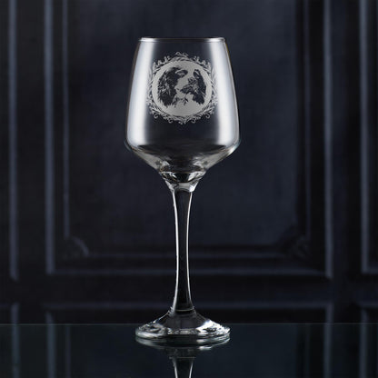 Clear wine glass with an english springer spaniel engraved design on a dark background