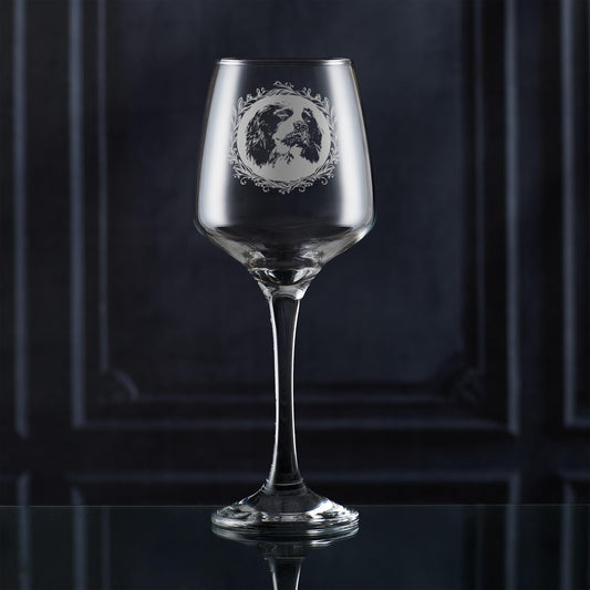 Clear wine glass with an english springer spaniel engraved design on a dark background