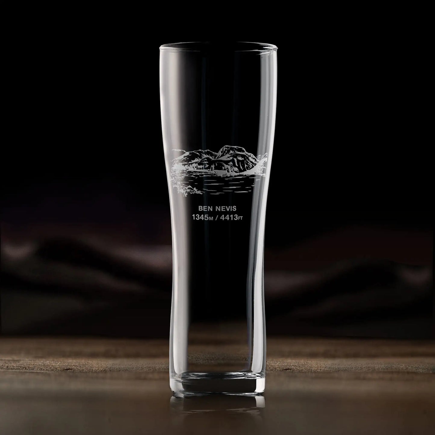 Pint glass engraved with Ben Nevis, photographed in situ on a wooden surface