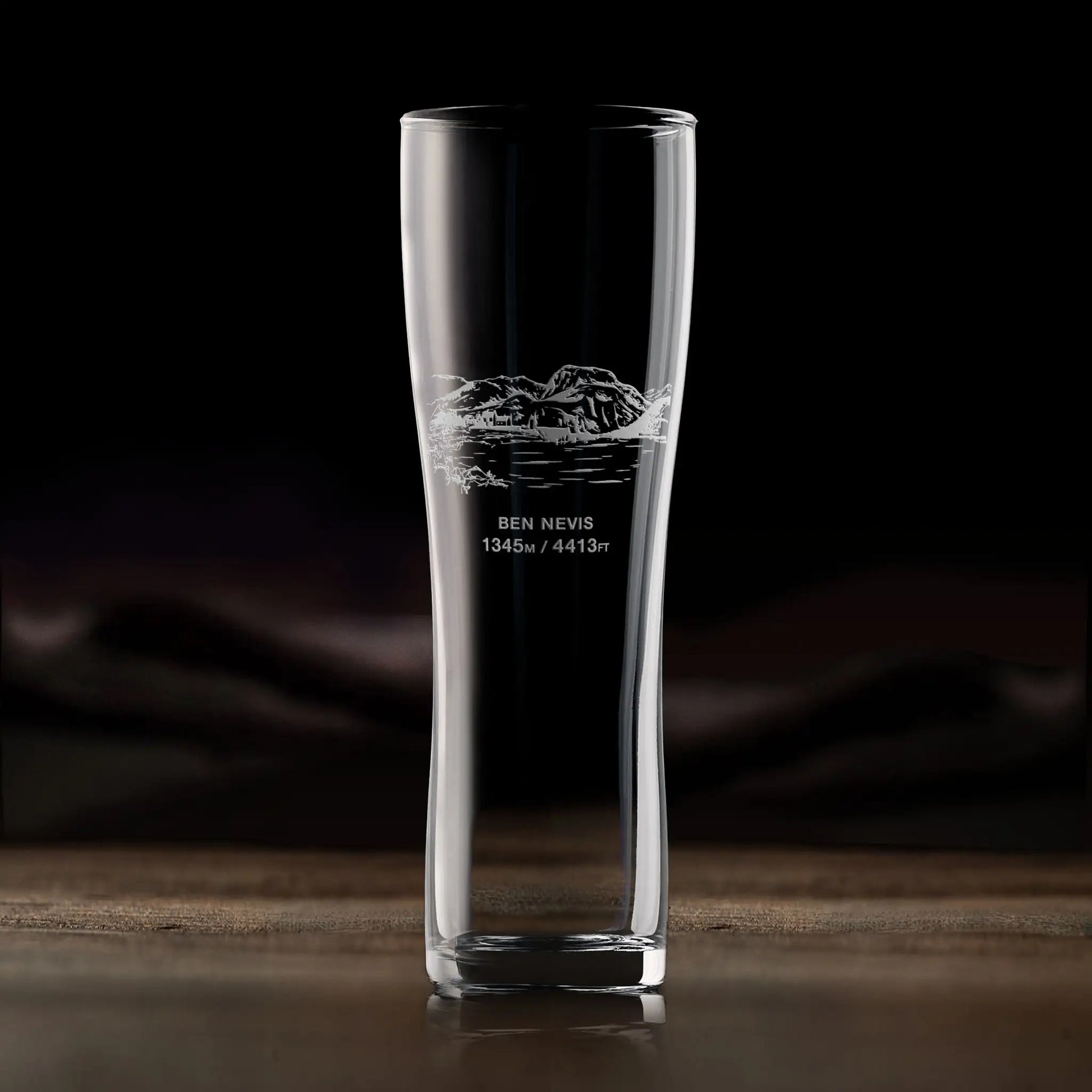 Pint glass engraved with Ben Nevis, photographed in situ on a wooden surface