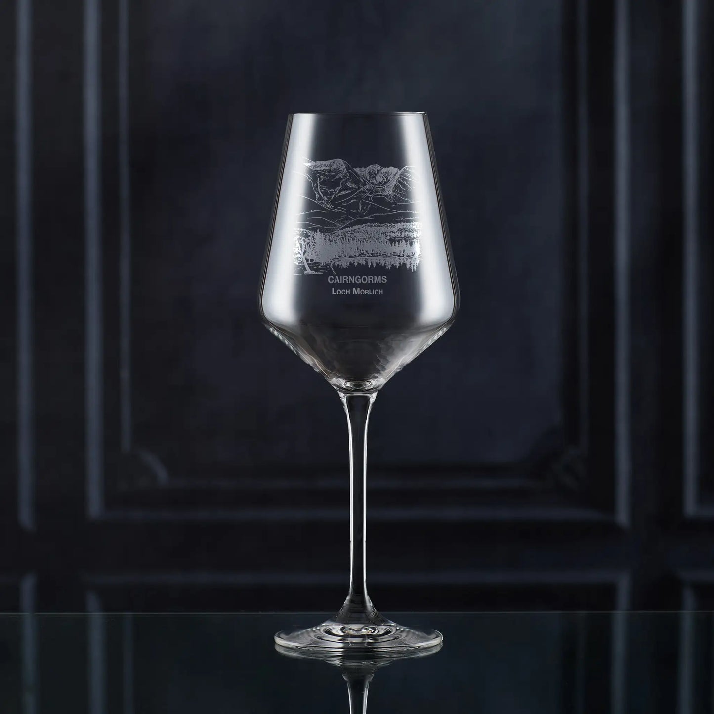 Engraved wine glass with Cairngorms and Loch Morlich landscape, shown on black background to highlight engraving detail