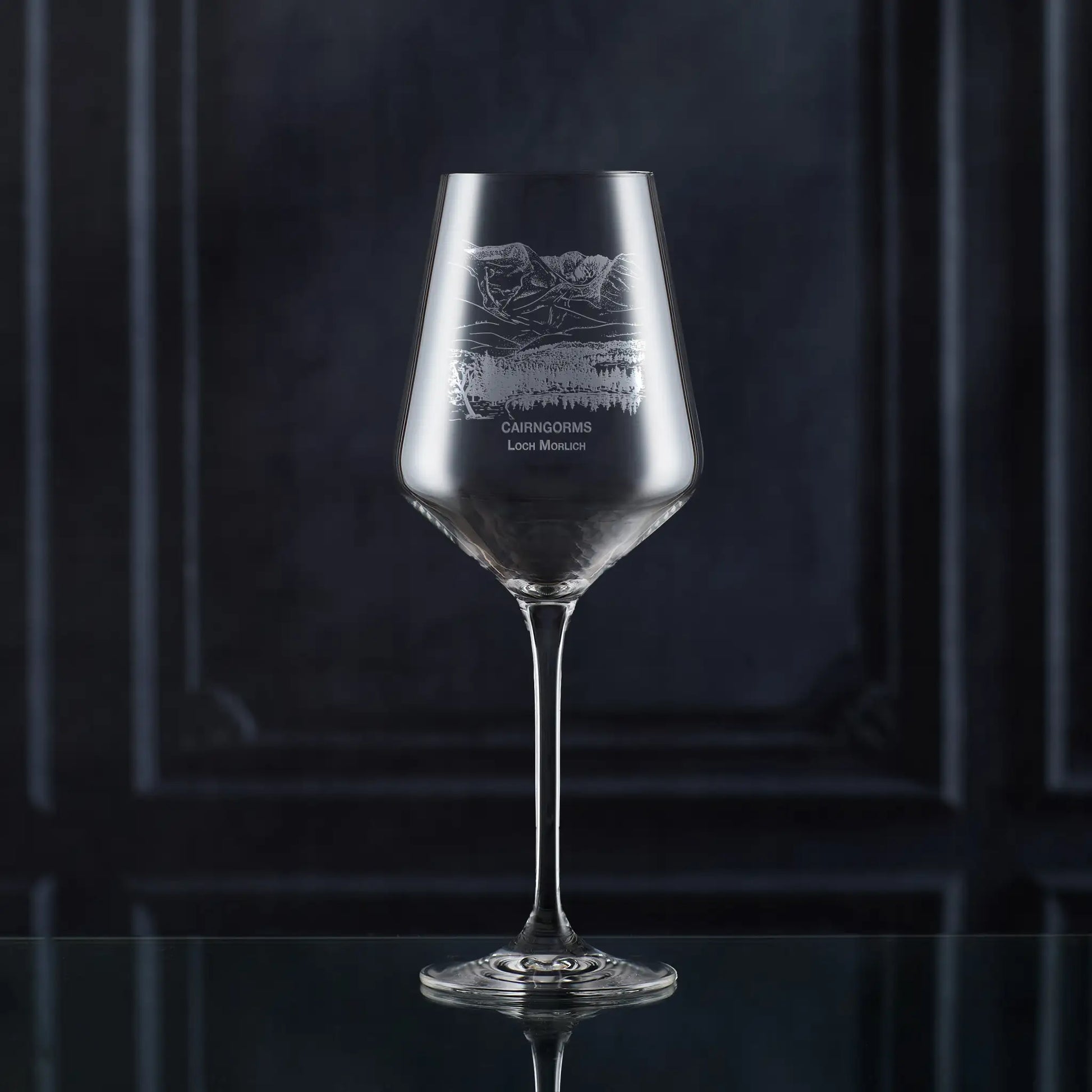 Engraved wine glass with Cairngorms and Loch Morlich landscape, shown on black background to highlight engraving detail