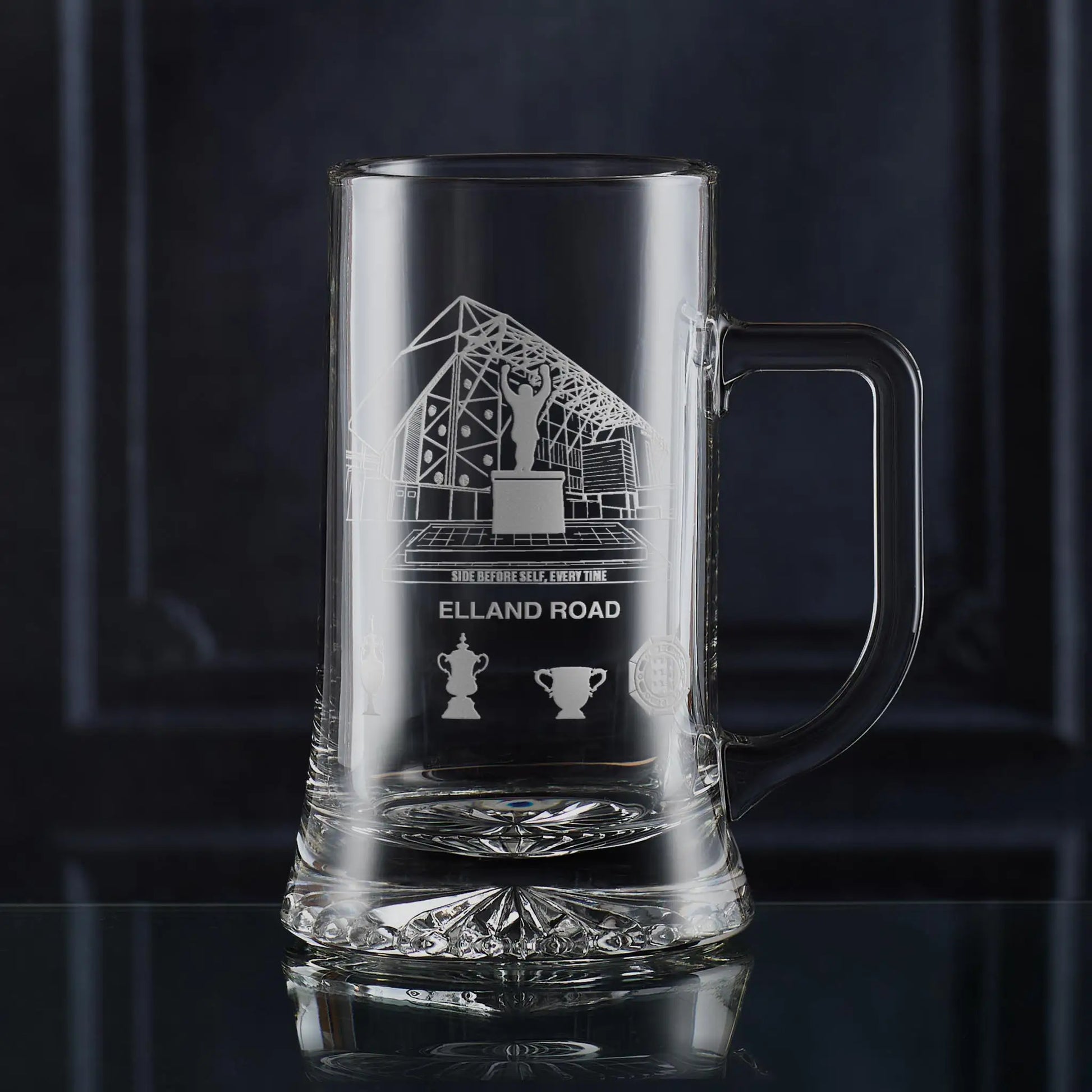 Engraved tankard featuring line-art architectural interpretation of Elland Road with trophy silhouettes beneath.