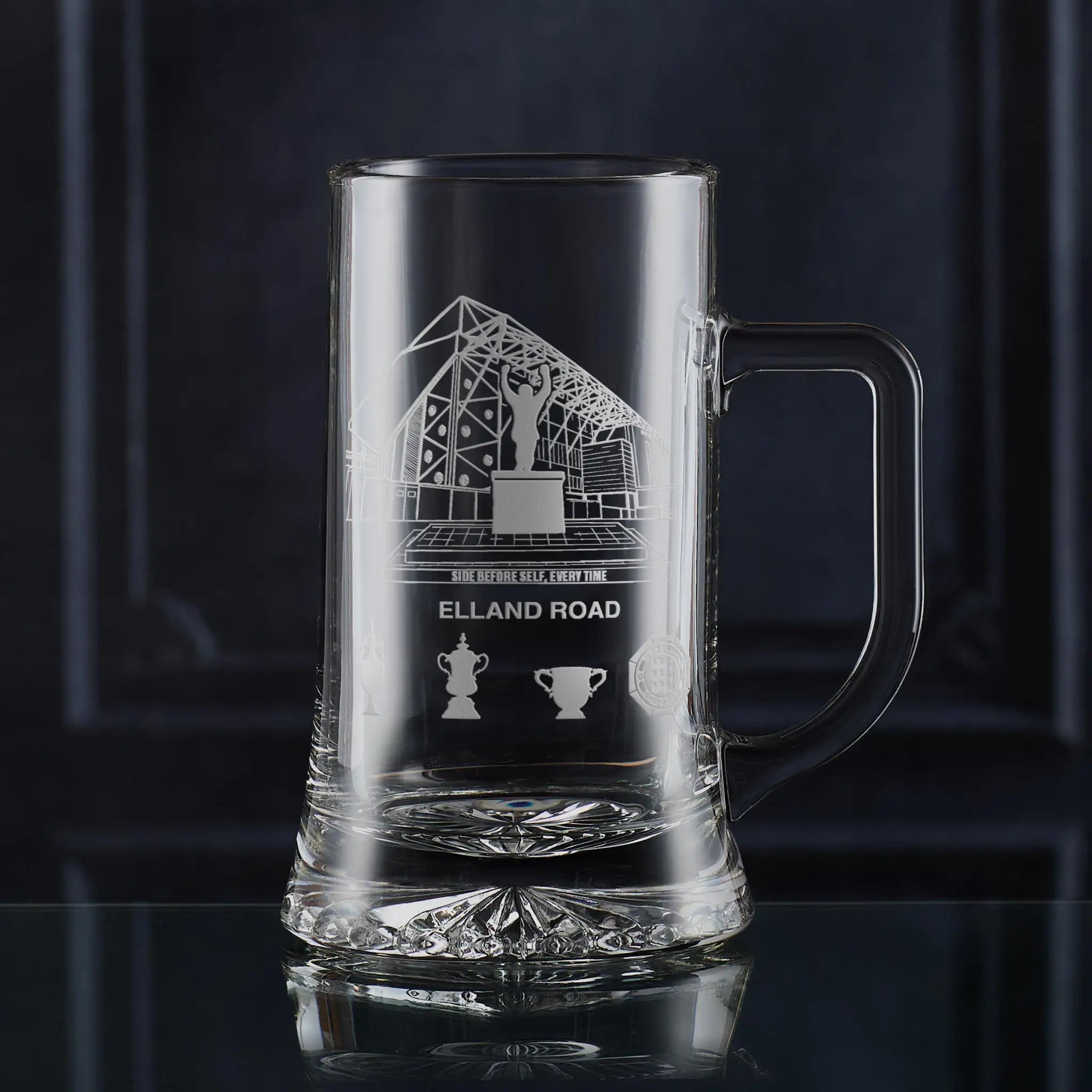 Engraved tankard featuring line-art architectural interpretation of Elland Road with trophy silhouettes beneath.