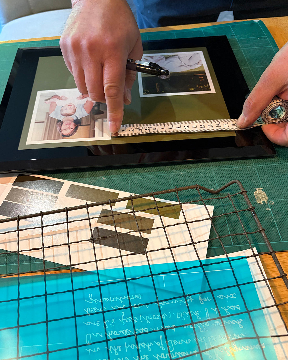 Printed family photographs positioned in the frame to align the handwriting engraving on the glass