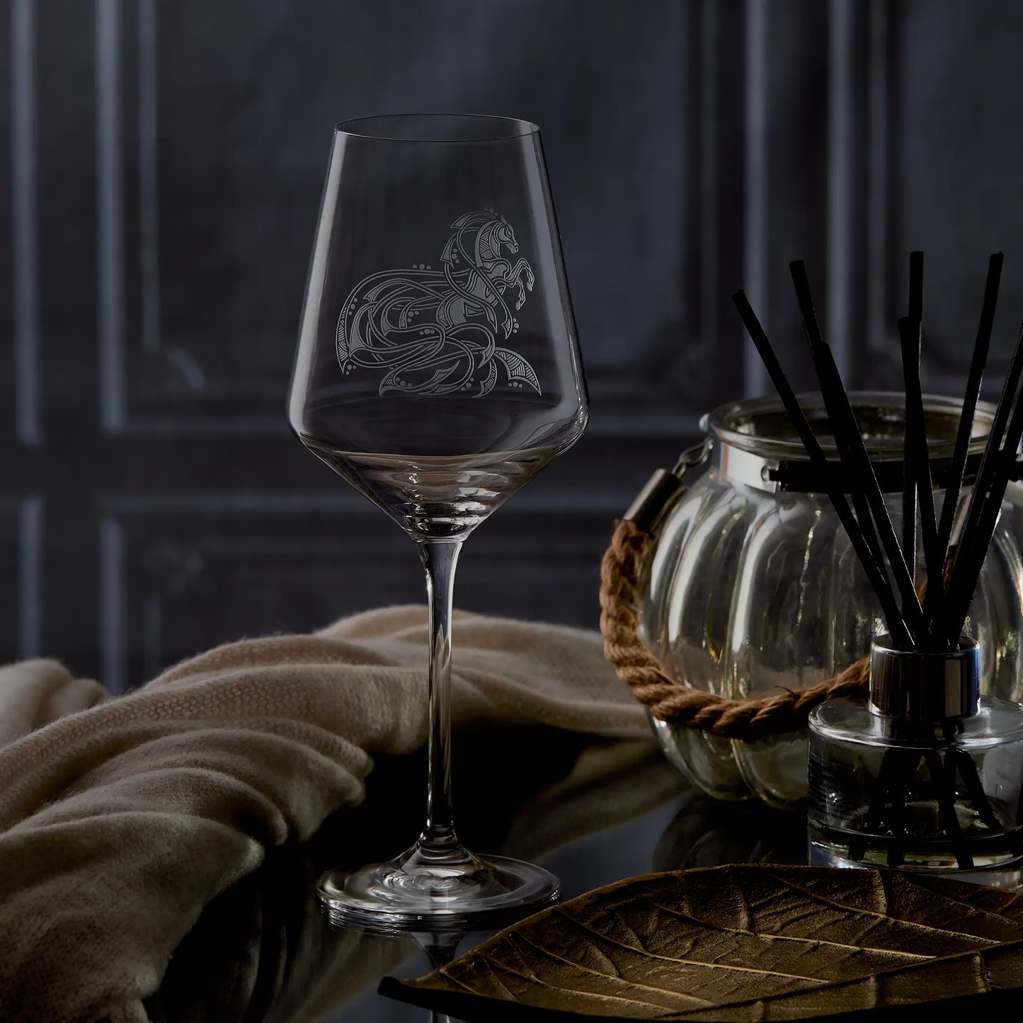 Horse wine glass with intricate knotwork design on a dark background with candles and flowers