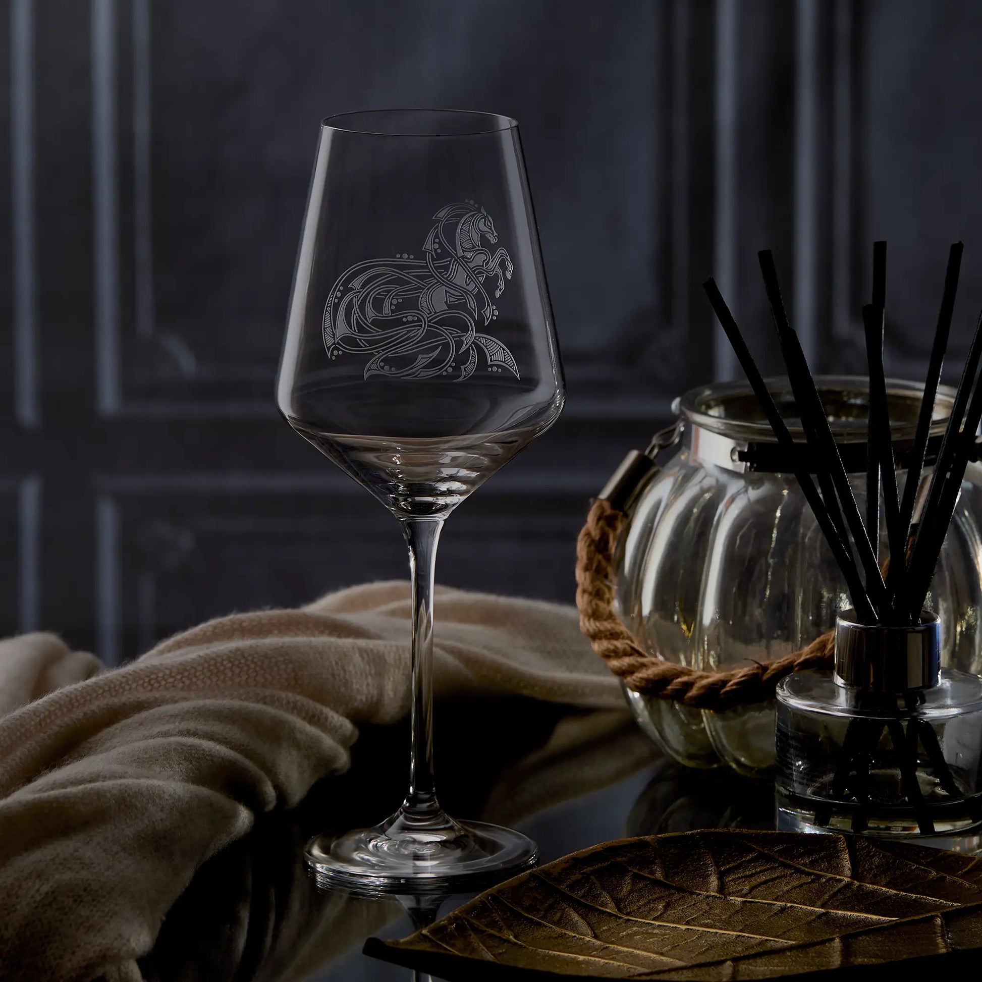 Horse wine glass with intricate knotwork design on a dark background with candles and flowers