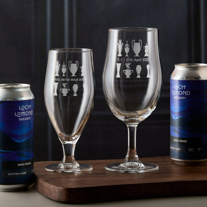 Engraved stemmed beer glass featuring a Liver Bird-inspired design and two rows of football trophy silhouettes.
