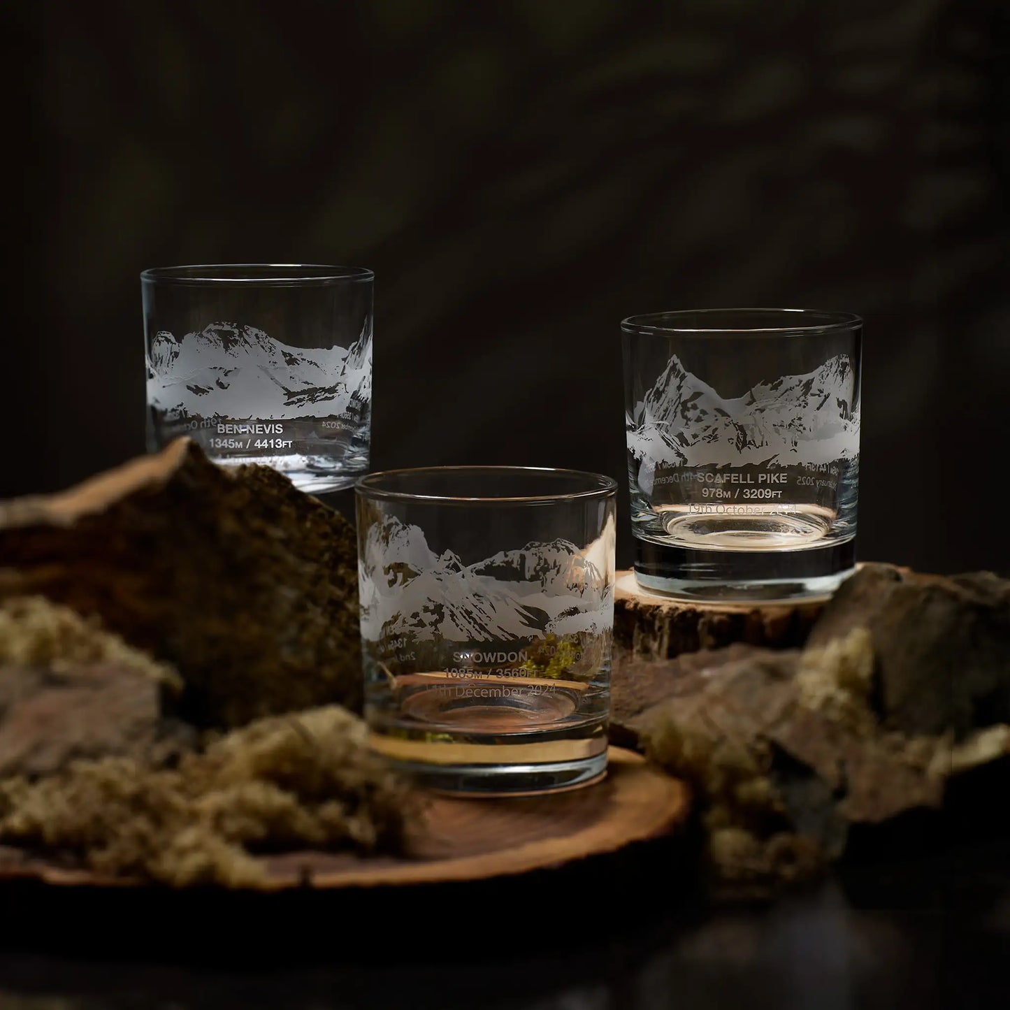 Whisky glass engraved with a wraparound design of Ben Nevis, Scafell Pike and Snowdon, photographed on a white background