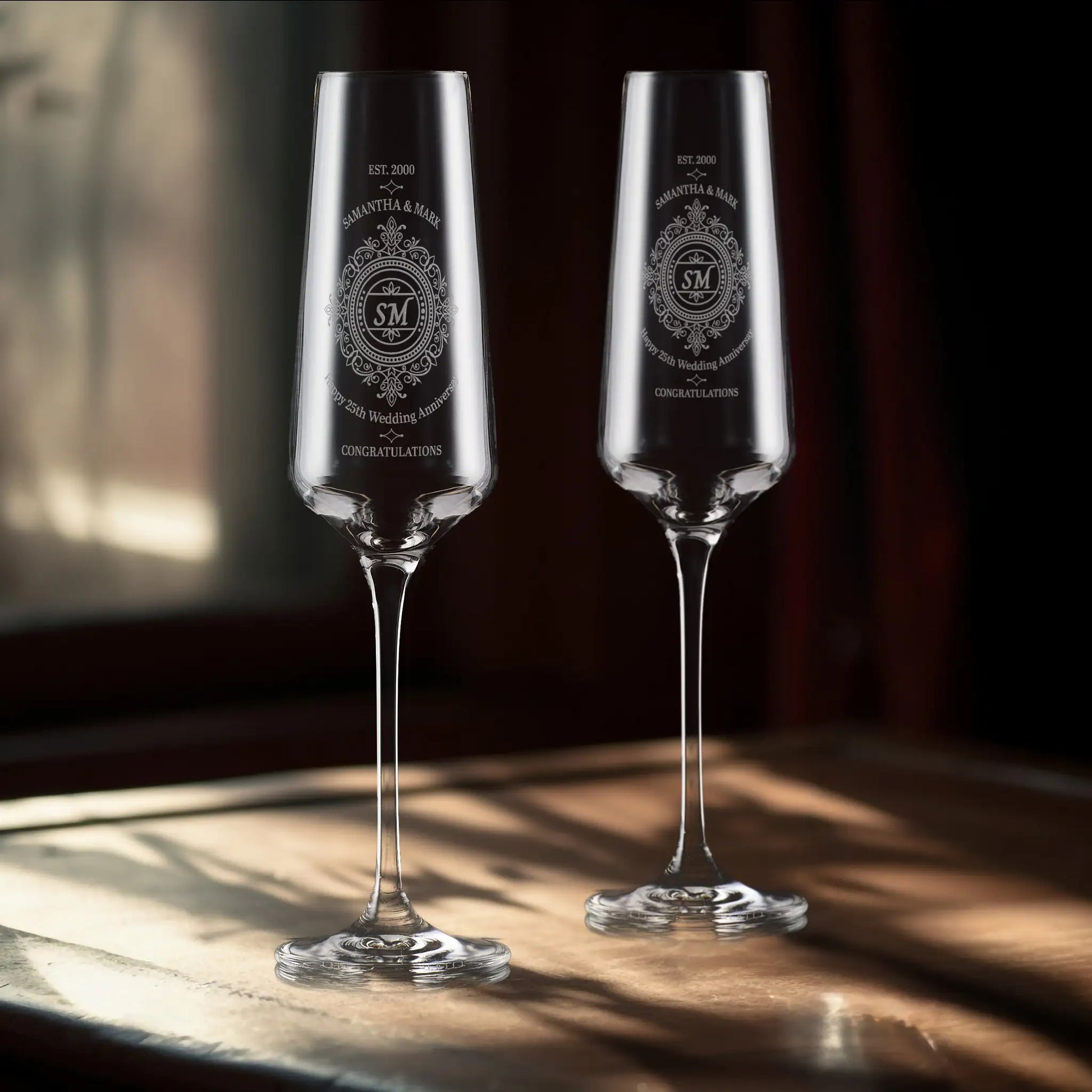 Pair of personalised anniversary champagne flutes engraved with lace pattern, initials, names, and message