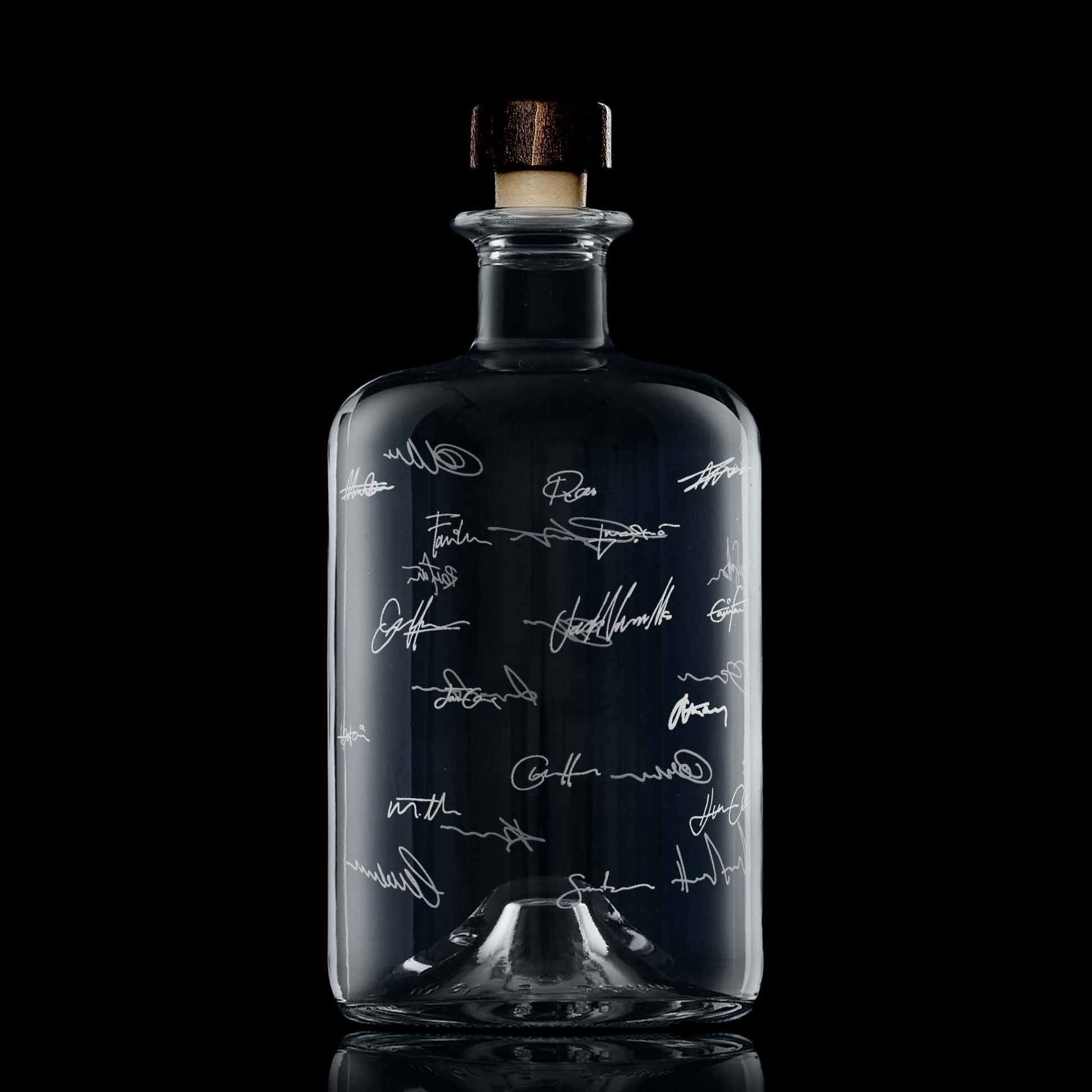 Engraved apothecary style whisky bottle with wraparound signature design on black background, highlighting deep satin engraving