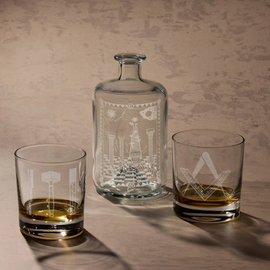 Entered Apprentice 1st Degree gift set featuring engraved apothecary decanter bottle with tracing board design and two whisky glasses with Masonic Square and Compass tools.