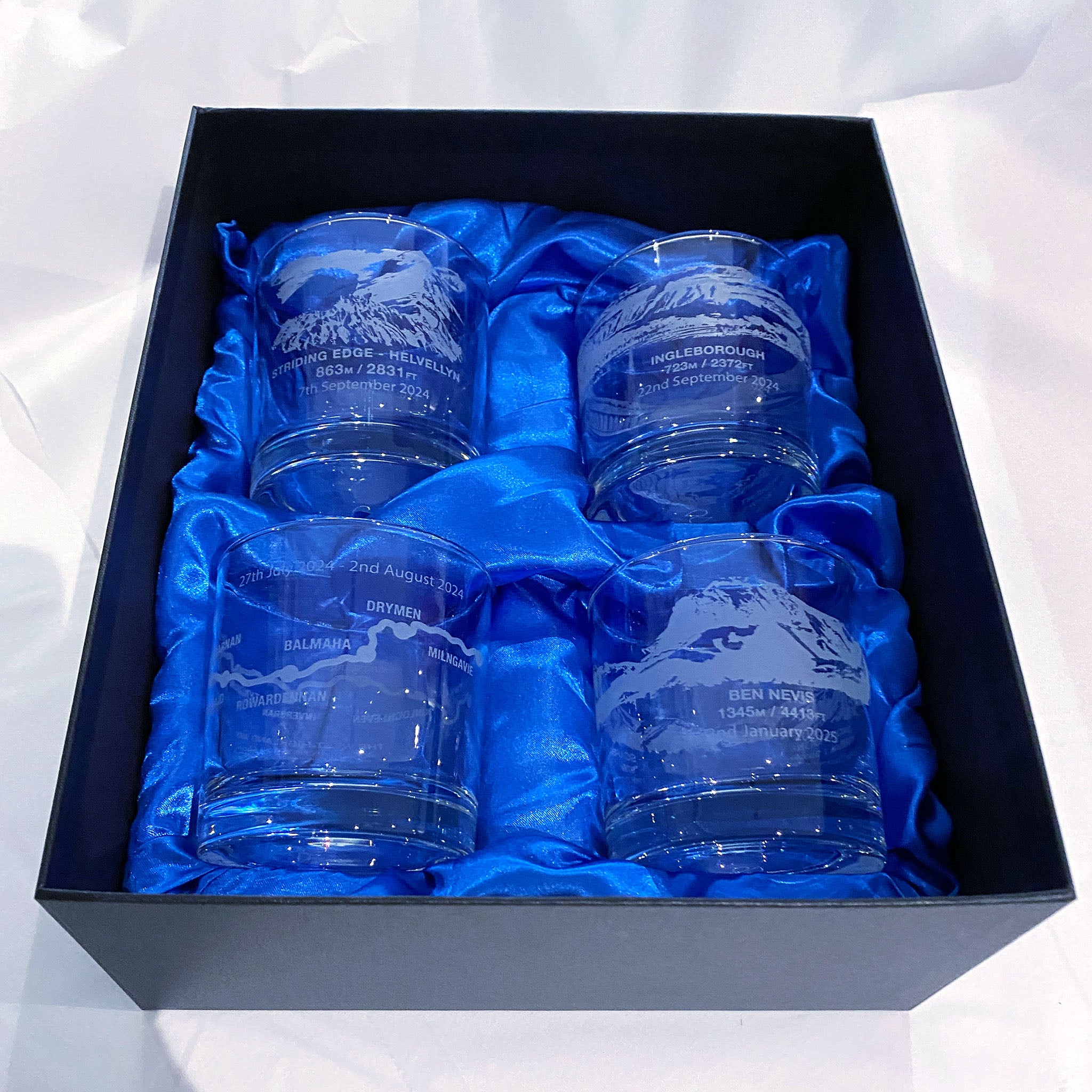 Set of four engraved whisky glasses in a black satin-lined presentation box, crafted for a personalised hillwalkers gift.