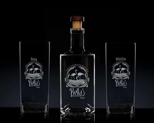 Bella's Bar bottle and two glasses with engraved designs on a dark background