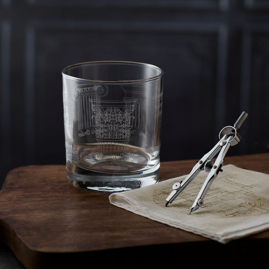 Whisky Glass with engraved architecture design on a wooden surface with a map and compass.