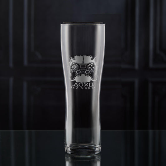 Pint glass with engraved games controller design on a dark background