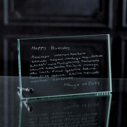 Glass plaque with engraved birthday message on a reflective surface