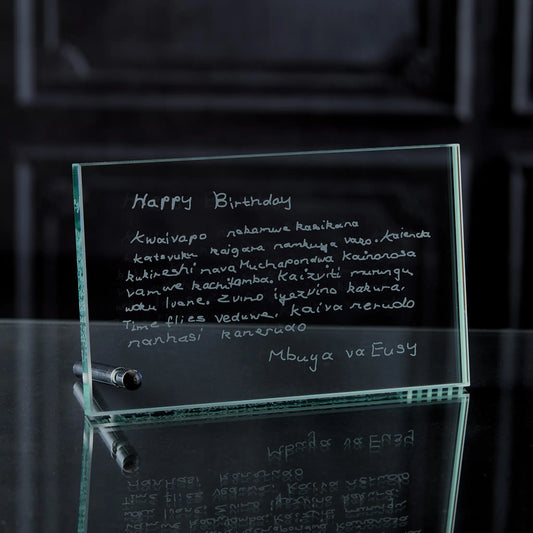 Glass plaque with engraved birthday message on a reflective surface
